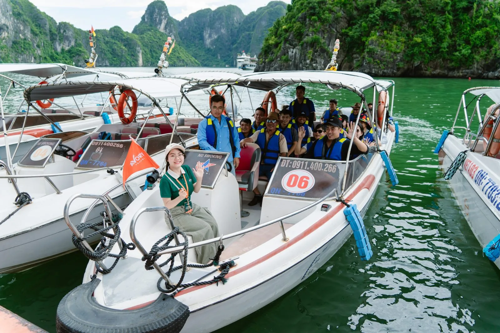 Hướng dẫn viên và đoàn khách trên ca nô khám phá vịnh Hạ Long
